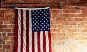 American Flag Hanging On The Brick Wall