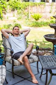 Happy Man Sitting On Patio Lounge Chair