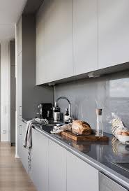 Homedit had a light grey and white design up their sleeve as well. A Minimalist Grey Kitchen With A Concrete Backsplash Covered With A Glass Screen Completely For Keeping It Clean Kitchen Design Concrete Kitchen Modern Kitchen