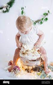 Toddler girl sitting on cake Stock Photo - Alamy