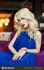 y blonde in blue dress sitting in a