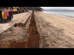Crews Build Sea Wall On Beach In Empire