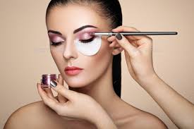 makeup artist applies eye shadow stock