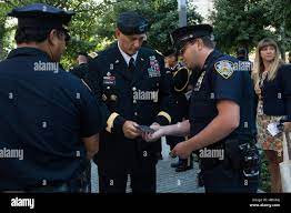 A New York Police Officer presents Chief of Staff of the U.S. Army Gen.  Raymond T. Odierno, center, with his department's patch during a tour of  the 9/11 Memorial and Museum in