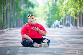 Picture Of Young Fat Man Having Heart Pain After Running While Sitting In  The Park Stock Photo, Picture and Royalty Free Image. Image 129926228.