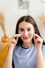 young woman using makeup remover at