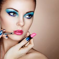 makeup artist applies lipstick