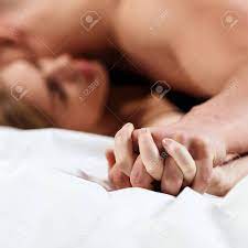 若い恋人がベッドでキスをする。セックスを持つカップルの手に焦点を当てた。の写真素材・画像素材 Image 95748270