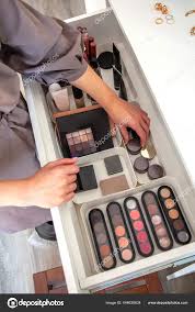 woman hands neatly organizing makeup