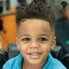 Following are the trendiest haircuts you can incorporate with your toddler boy's curly hair. Guy Hairstyles Toddler Black Curly Hair Undercut Blue Shirt Large Brown Eyes In 2020 Boys Haircuts Little Black Boy Haircuts Black Kids Haircuts