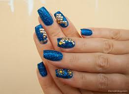 blue glitter manicure with gold rhinestones