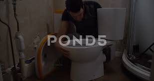 plumber installing a new toilet in a