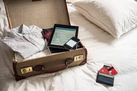 open suitcase on bed with digital