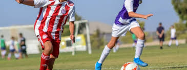 youth soccer players run in a game