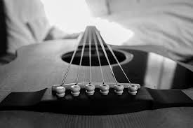 greyscale photo of acoustic guitar on