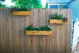 The chic pallet garden fence in a black finish with some colorful buckets colorize it uniquely. Yard Update And Diy Cedar Planter Boxes The Suburban Urbanist