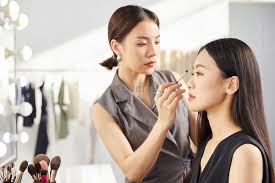 makeup artist puts makeup on model