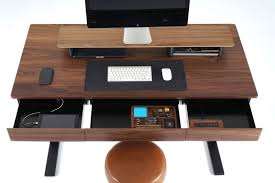 Three drawers on one side with a more substantial utility drawer in the center, below the work surface. Woolsey Standing Desk With Three Drawers And Wireless Charging