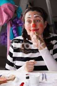 woman putting on clown makeup stock