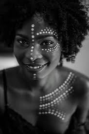 happy black woman with dots of paint on