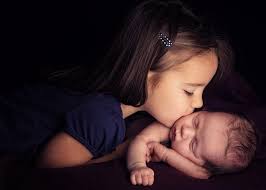 little kissing her baby brother