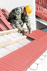 roofer nailing clay tile stock photo by