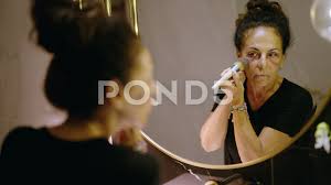 middle age hispanic woman using makeup