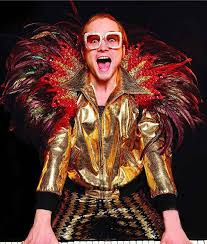 The musician has a repertoire of outfits that have become as famous as his hits. Elton John Rocketman Taron Egerton Golden Satin Jacket Elton John Rocketman Movie Elton John Costume