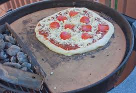 a pizza stone on a charcoal grill