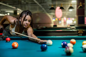 female player playing pool and aiming