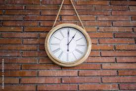 Wall Clock Hanging In A Red Brick Wall
