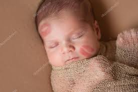 newborn baby with lipstick kisses on