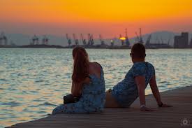 romantic couple sitting on the pier at