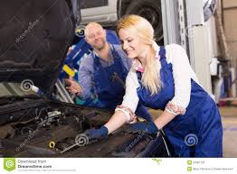 Mechanic And Assistant Working At Auto Repair Shop Stock