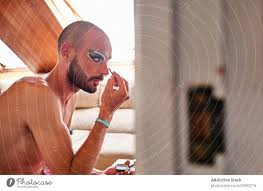 bearded man applying drag queen makeup