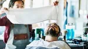 barber puts a hot towel on your face