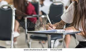 Abstracts and Appendices   APA Guide   Guides at Rasmussen College  Student hand holding pen writing doing examination with blurred abstract  background university students in uniform attending