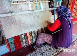 woman weaving a turkish carpet or rug