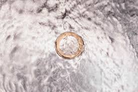 euro coin in kitchen sink with flowing