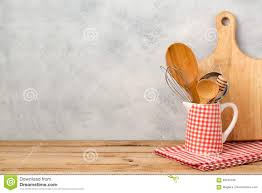 Kitchen Utensils And Cutting Board On Wooden Table Over