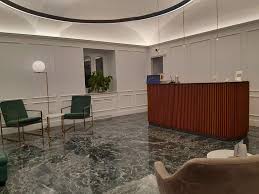 Esta sala de jantar leva piso de cimento queimado combinado com parede em azul esverdeado, mesa com tampo de vidro e bancada de madeira no espaço do escritório. Hotel En Cuneo Best Western Plus Hotel Royal Superga