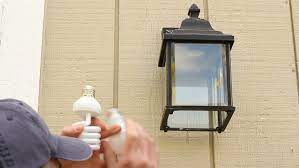 man outside changing an incandescent