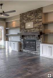 stone fireplace with bookshelves on each side on i really like this stackstone fireplace with the built in cabinets on either side and the shelf stacked stone fireplaces built in cabinets fireplace built ins pinterest