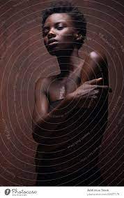 Verführerische schwarze Frau steht im dunklen Studio - ein lizenzfreies  Stock Foto von Photocase