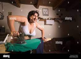 Merry woman in bra with big breasts ironing clothes at home Stock Photo -  Alamy
