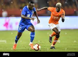 Ivorian football player Jean Evrard Kouassi, right, of Wuhan Zall  challenges Cameroonian football player Christian Bassogog of Henan Jianye  in their 4 Stock Photo - Alamy