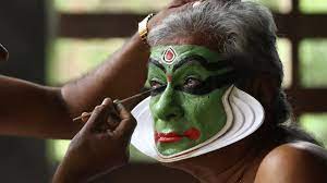 kathakali artist applying makeup