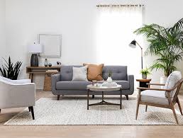 A large contemporary sectional sofa in a neutral tone and plenty of neutral grey and wood tones make for an inviting industrial living room. Living Room Ideas Decor Living Spaces