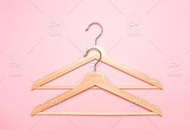 Wooden Coat Hangers For Clothes On A Pink Background