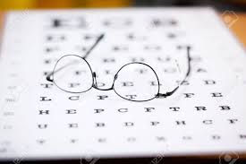 Glasses With Thin Frame Lying On Eye Test Chart